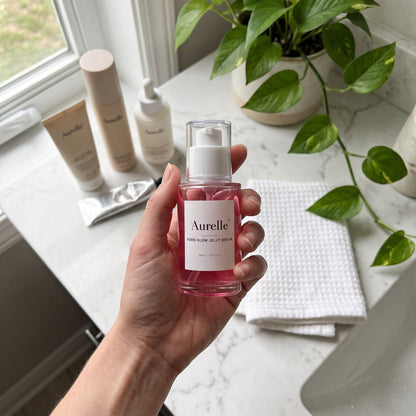 Aurelle jelly serum held over a marble bathroom counter, morning routine