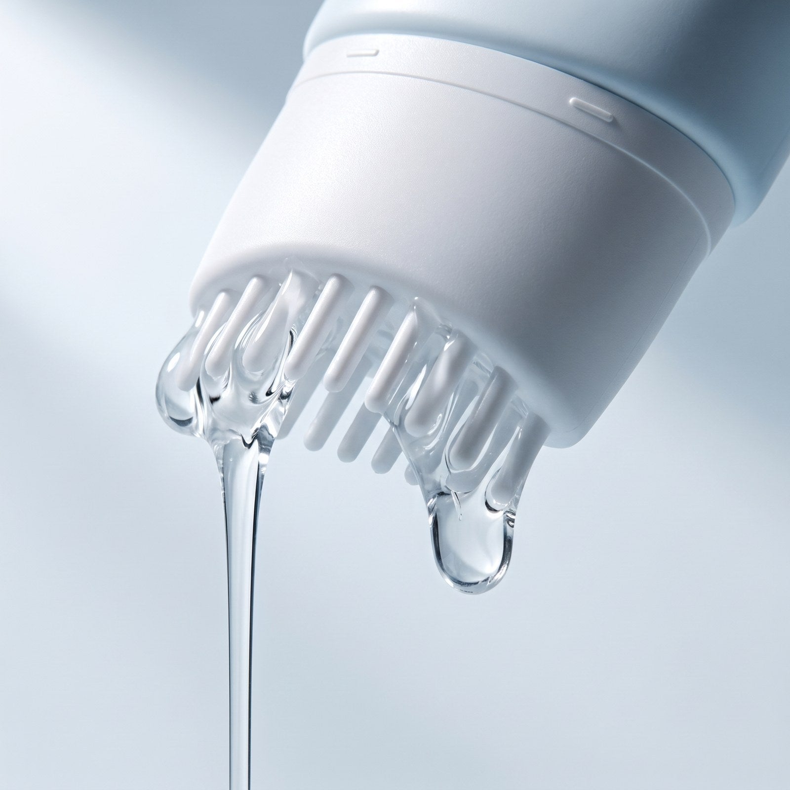 Macro of clear serum running out between the short white applicator teeth