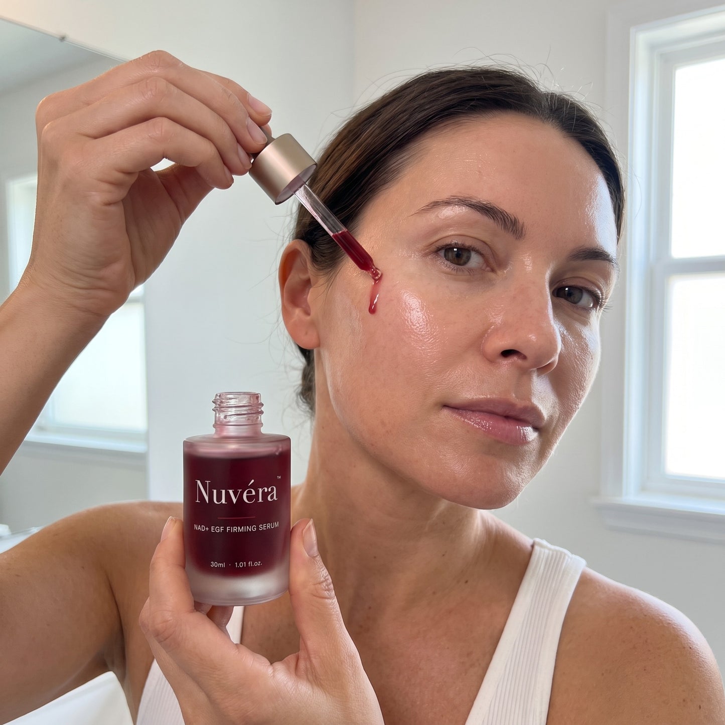 Nuvera NAD+ EGF Firming Serum applied to the face with the dropper